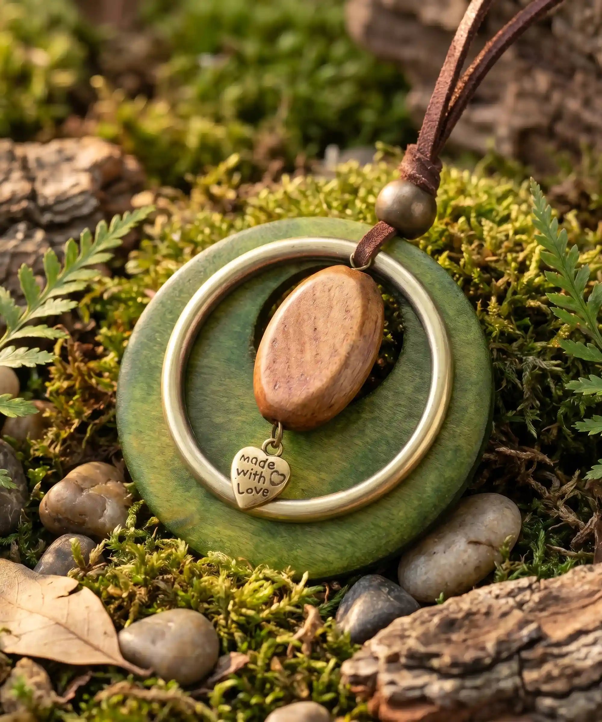 Pendentif bois vert sur lit de mousse et galets ronds, collier boheme inspire nature